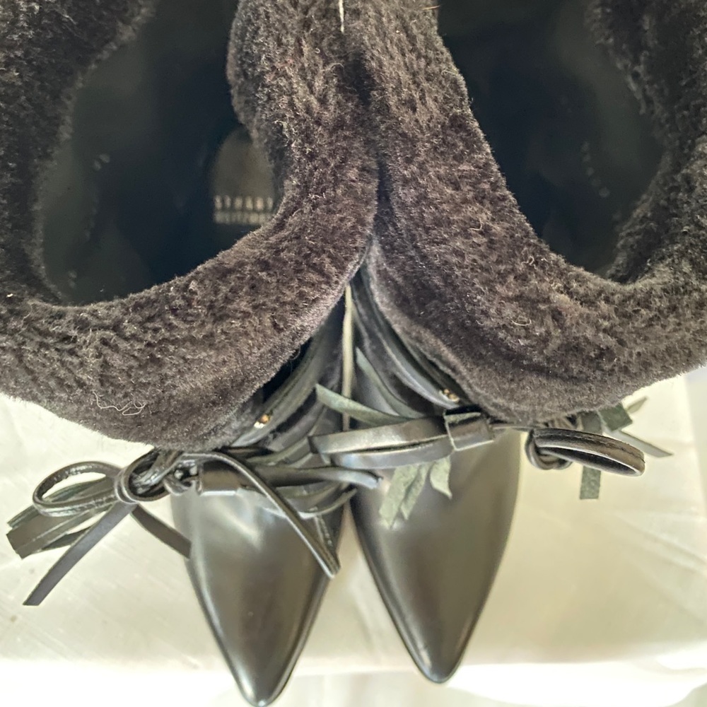 Stuart Weitzman winter boots with faux fur lining and tassel accents.